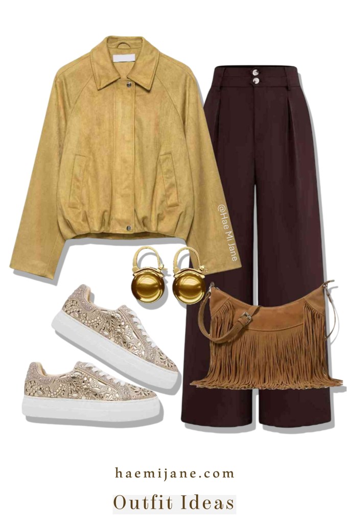 A stylish outfit featuring a mustard yellow suede bomber jacket, deep burgundy wide-leg trousers, rhinestone-embellished platform sneakers, a brown fringe handbag, and large gold sphere earrings